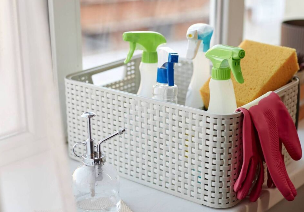 Organized basket of professional cleaning supplies and spray bottles for residential cleaning