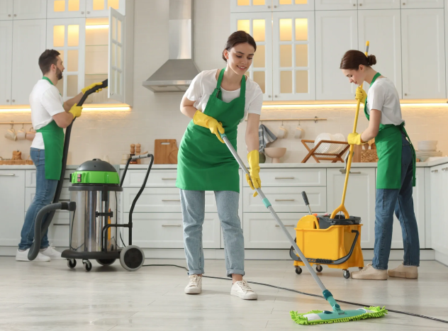 Professional house cleaning team mopping floors and cleaning kitchen